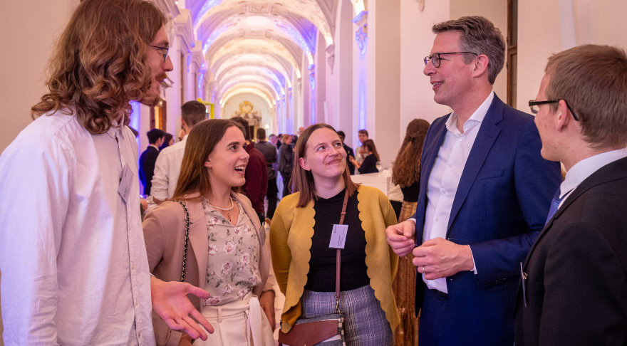 Wissenschaftsminister Markus Blume im Gespräch mit Mitgliedern des Elitenetzwerks Bayern (© StMWK/Andreas Heddergott)