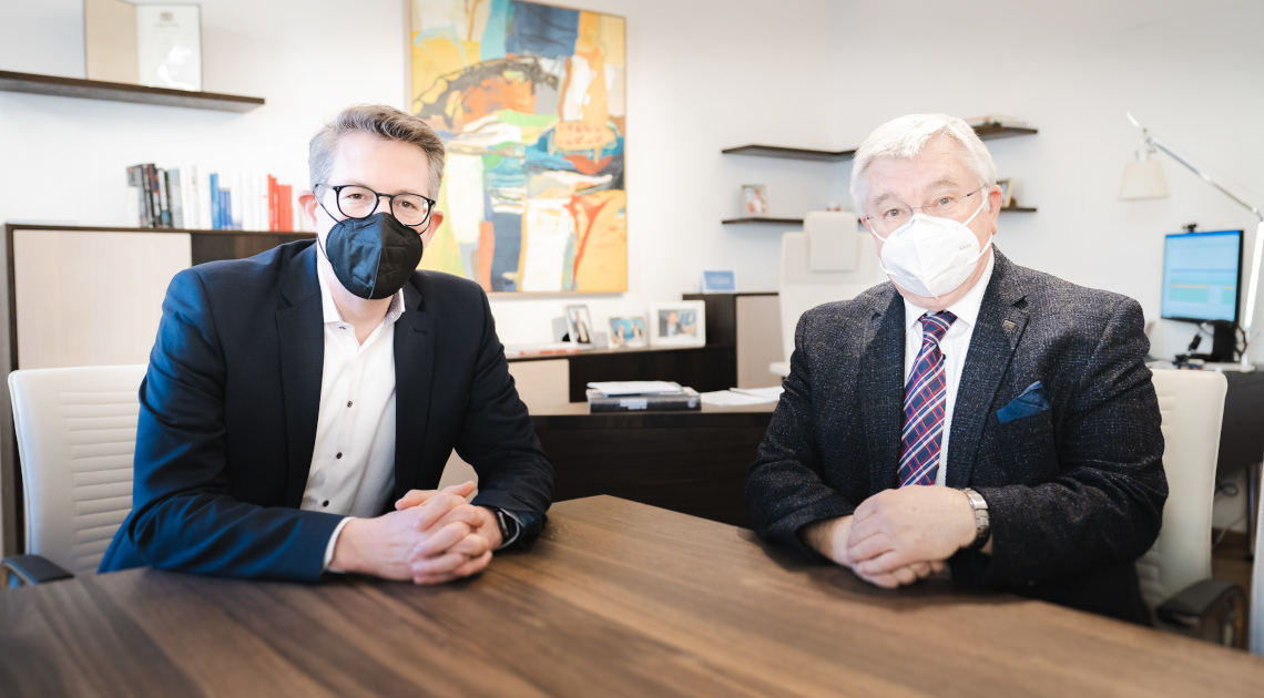 Wissenschaftsminister Markus Blume (links) bei einem Austausch mit dem wissenschaftlichen Gesamtkoordinator des Munich Quantum Valley Professor Rainer Blatt (rechts) in München (© StMWK/Axel König)